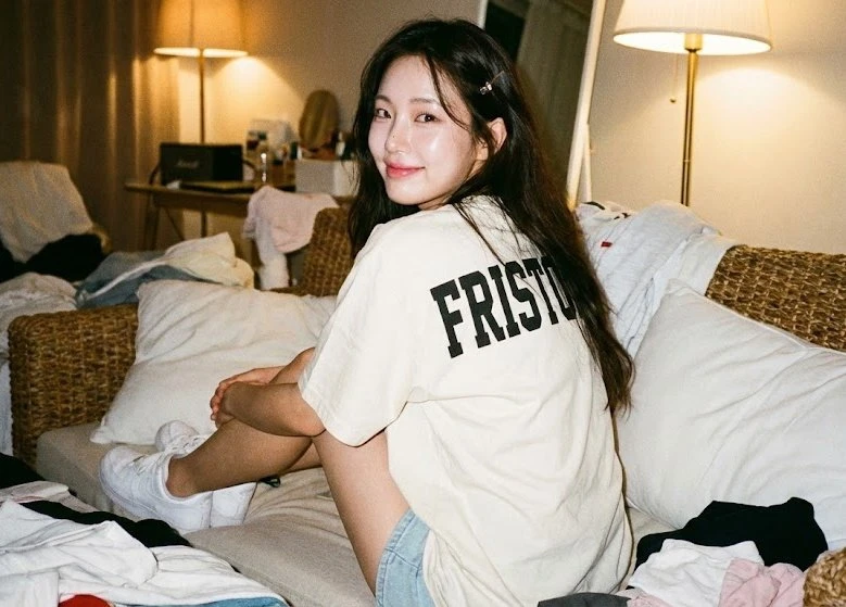 Girl sitting on a woven sofa with her back to the audience